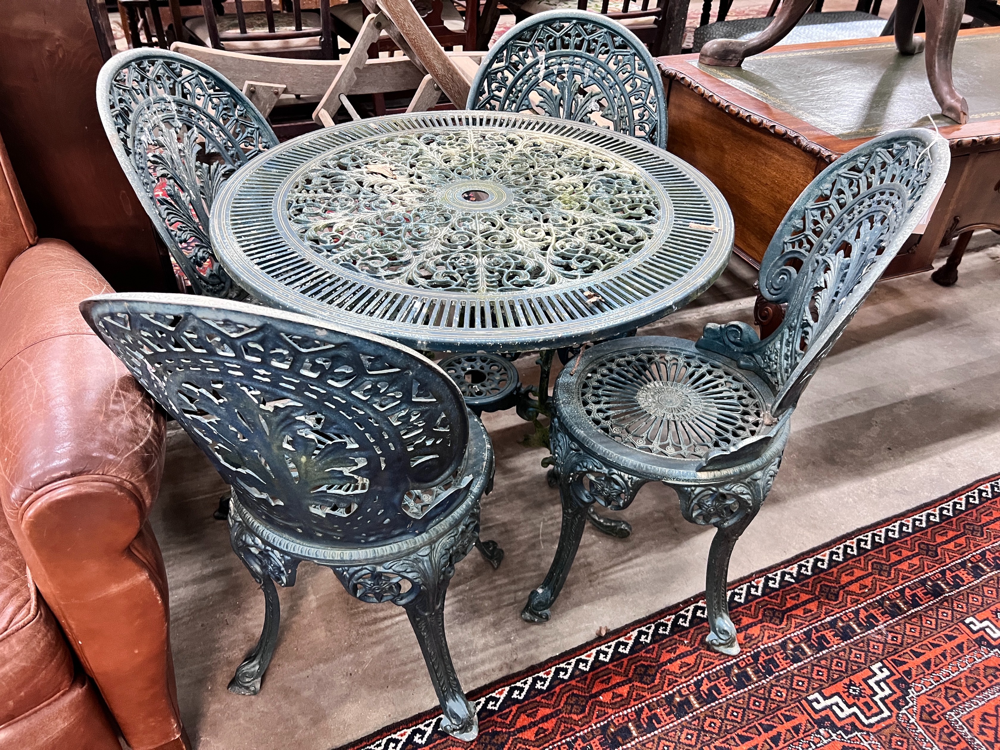 A Victorian style circular aluminium table, diameter 80cm, height 69cm and four matching chairs *Please note the sale commences at 9am.